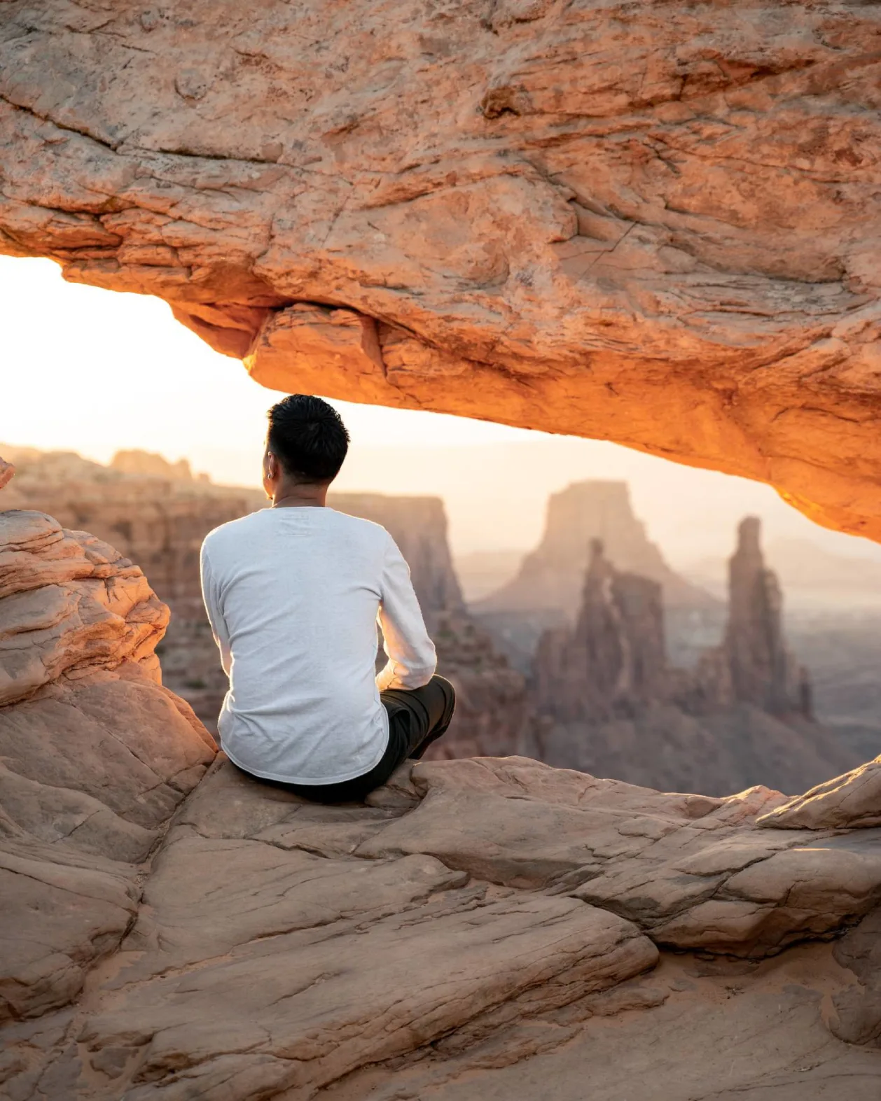 solo male hiker at sunrise canyon lands national park utah